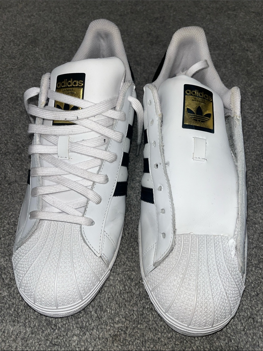 Classic white and black Adidas Superstar sneakers stand out with their signature